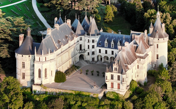 Aerial view of Chaumont-sur-Loire Castle surrounded by lush greenery.