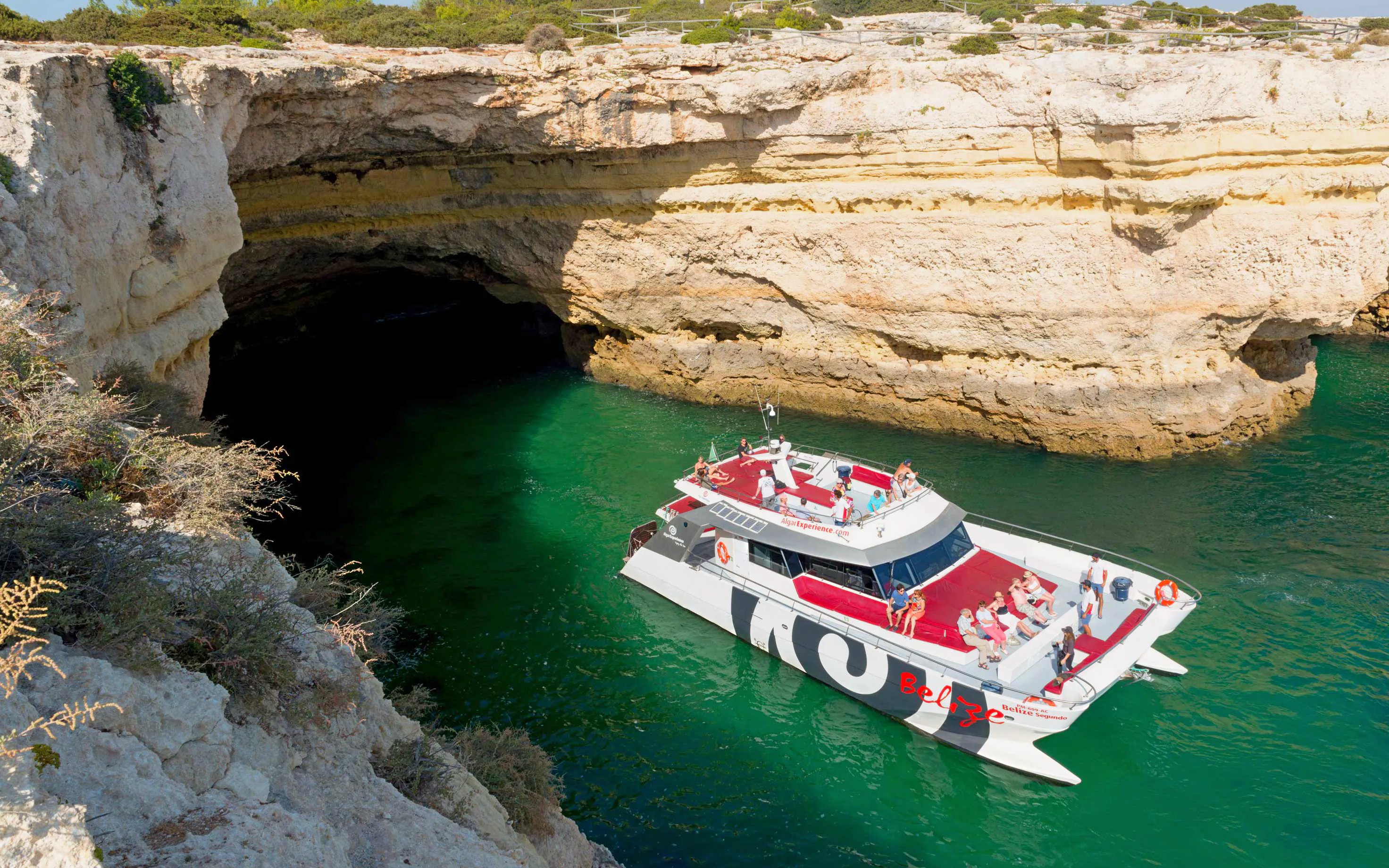 Boat approaching Benagil Caves entrance in Algarve, Portugal.