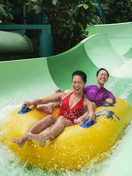 Two people enjoying a water slide ride at Sentosa with the Fun Pass.