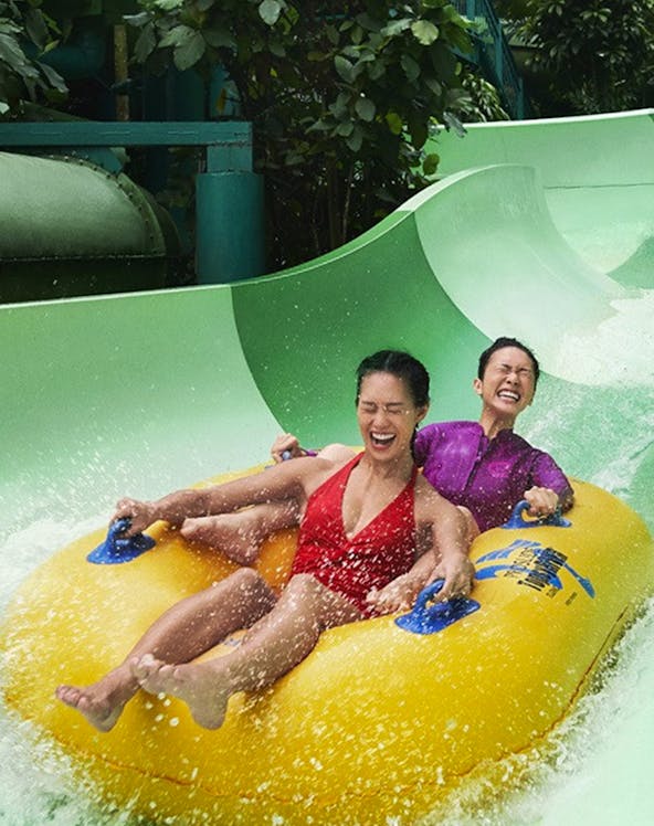 Two people enjoying a water slide ride at Sentosa with the Fun Pass.