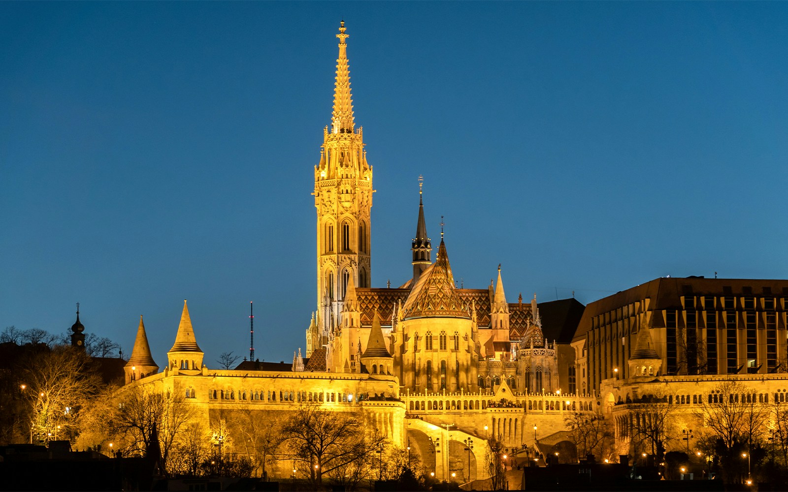 Fisherman's Bastion in Budapest with Danube River view at sunset.