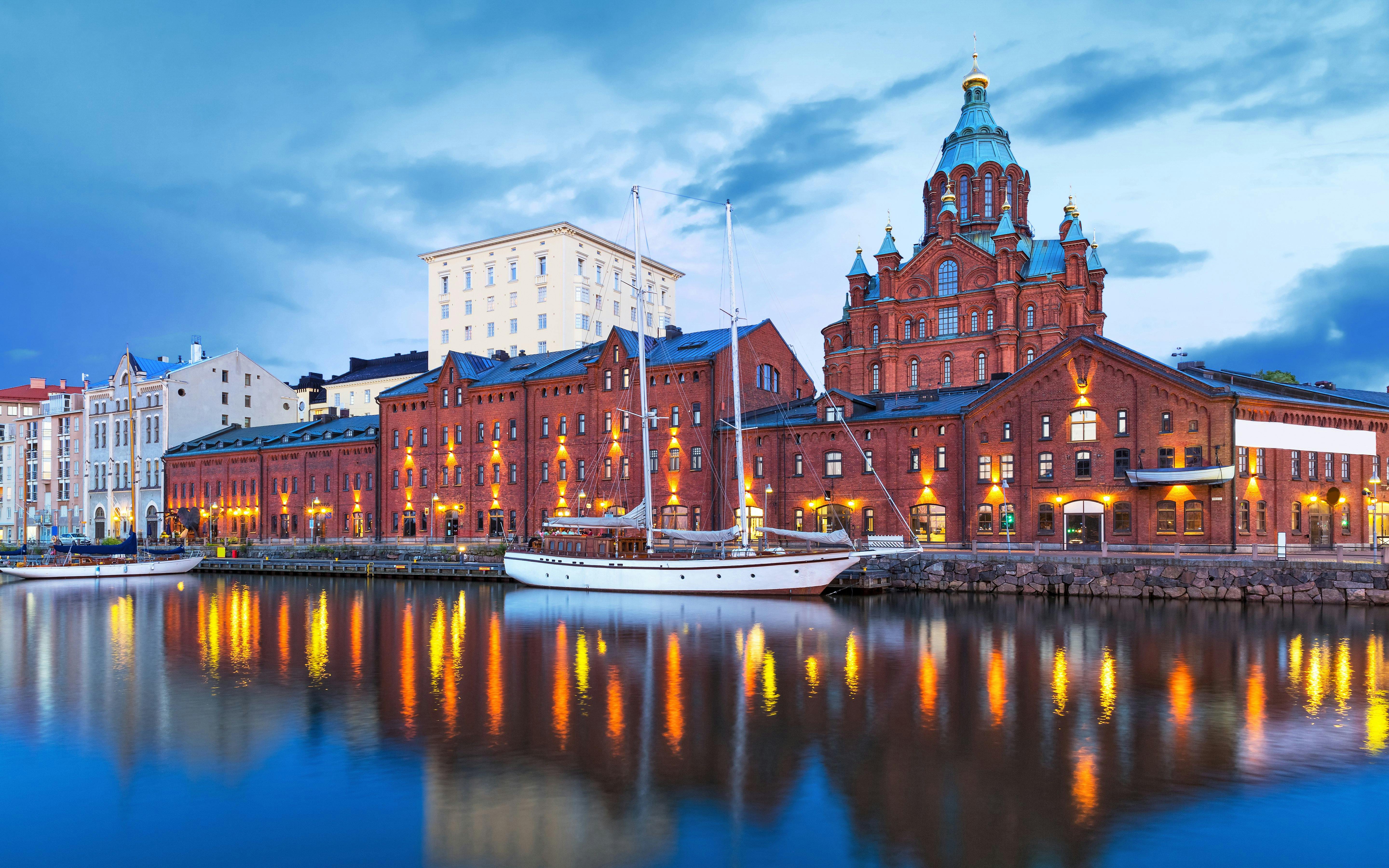 Uspenski Cathedral and waterfront buildings in Helsinki, Finland at dusk.