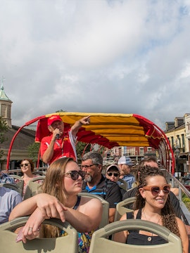 Open-top bus tour with guide pointing out sights in Milan.