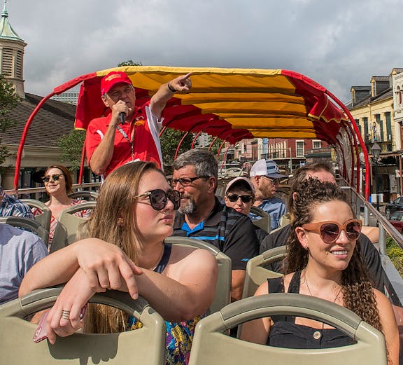 Open-top bus tour with guide pointing out sights in Milan.
