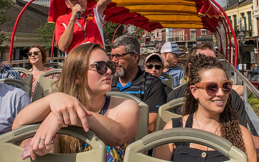 Open-top bus tour with guide pointing out sights in Milan.