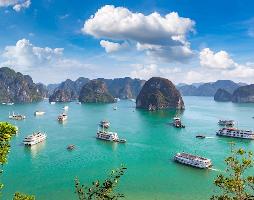 Cruise ships sailing among limestone islands in Halong Bay, Vietnam.