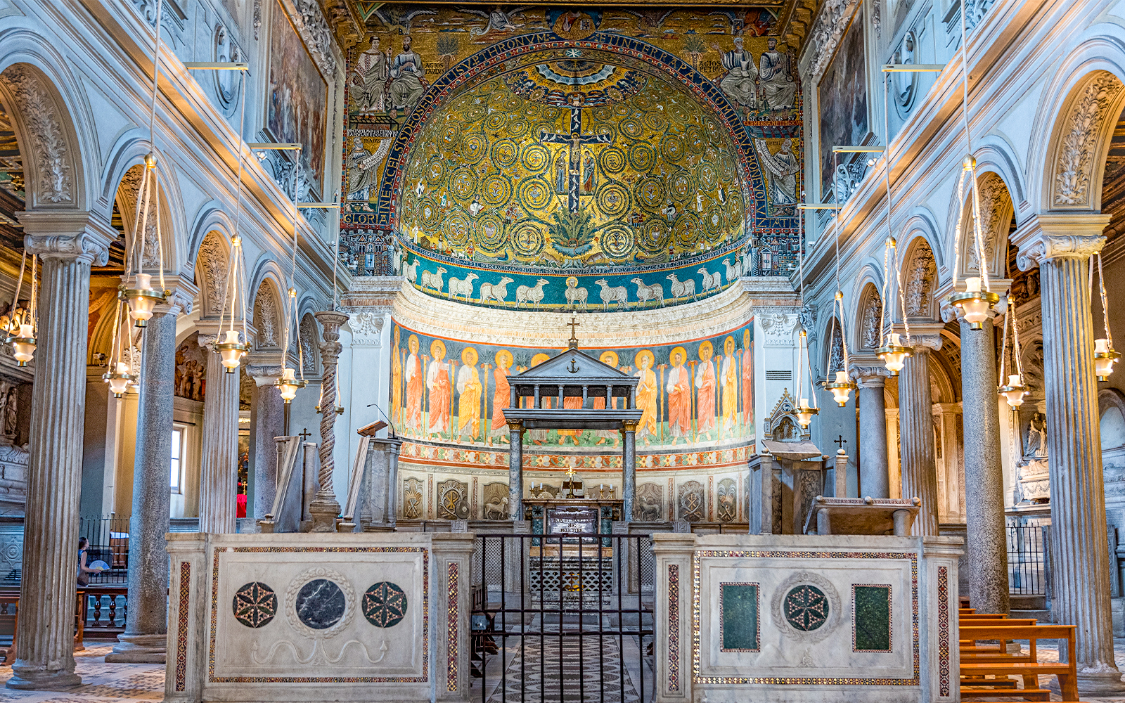 Basilica of San Clemente interior with ornate mosaics and arches, Rome.
