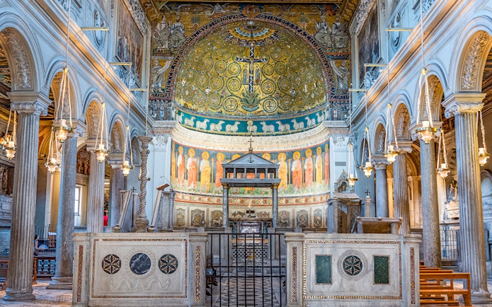 Basilica of San Clemente interior with ornate mosaics and arches, Rome.