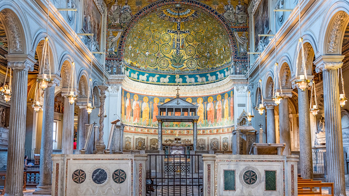 Basilica of San Clemente interior with ornate mosaics and arches, Rome.