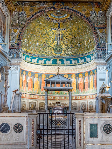 Basilica of San Clemente interior with ornate mosaics and arches, Rome.