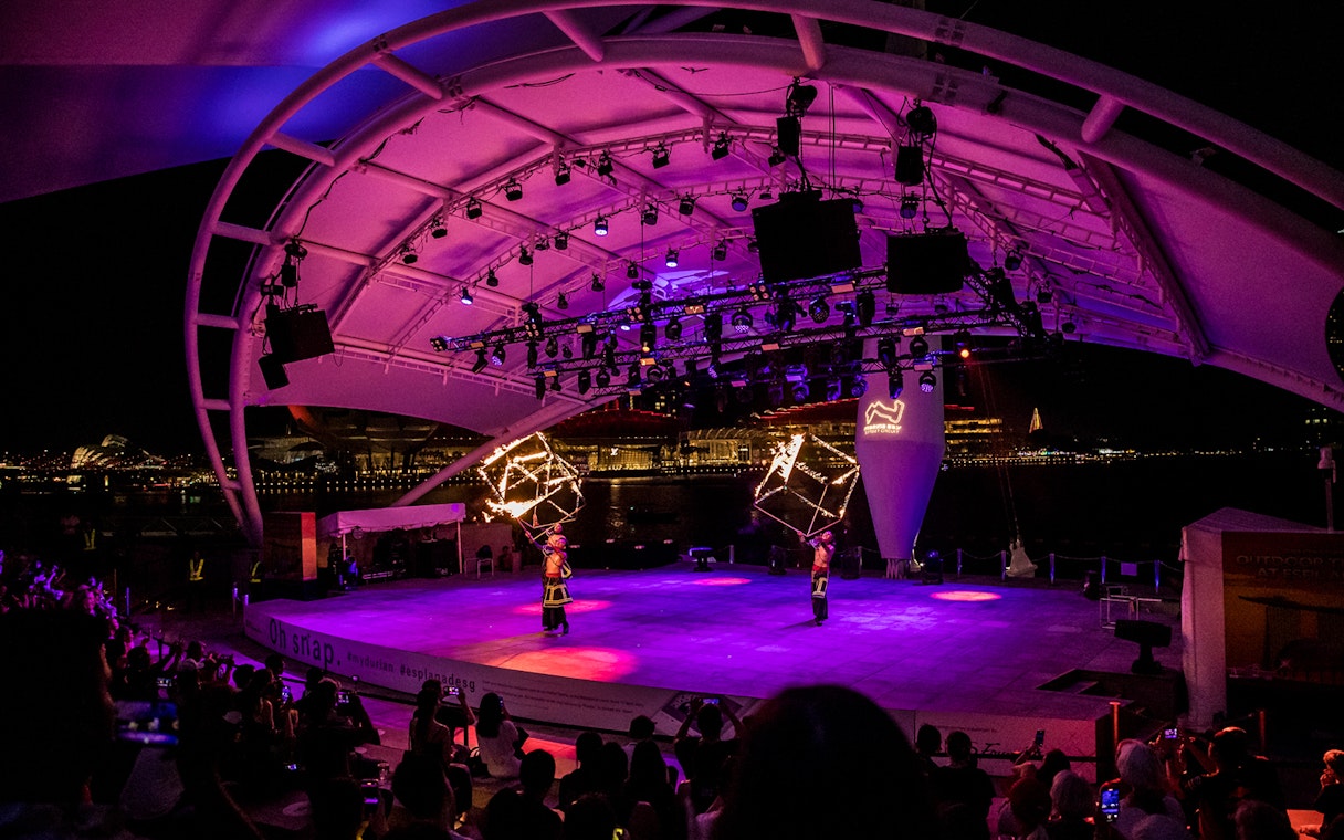 Performers with fire props on stage at Esplanade Outdoor Theatre, Singapore, during Formula 1 Grand Prix 2025.