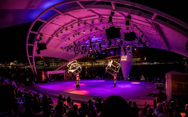 Performers with fire props on stage at Esplanade Outdoor Theatre, Singapore, during Formula 1 Grand Prix 2025.