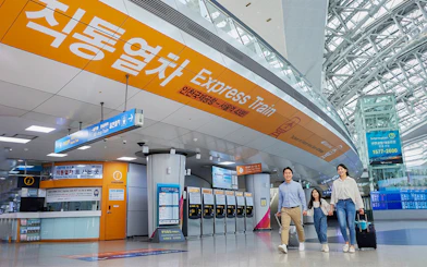 Incheon Airport Express Train station with travelers and ticket machines.
