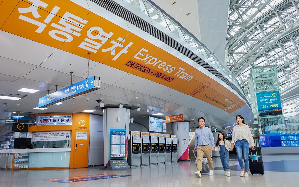 Incheon Airport Express Train station with travelers and ticket machines.