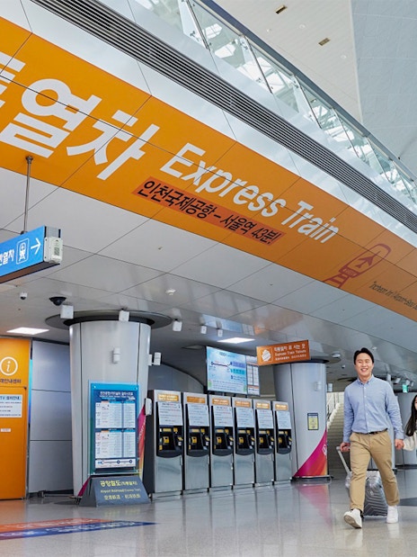 Incheon Airport Express Train station with travelers and ticket machines.