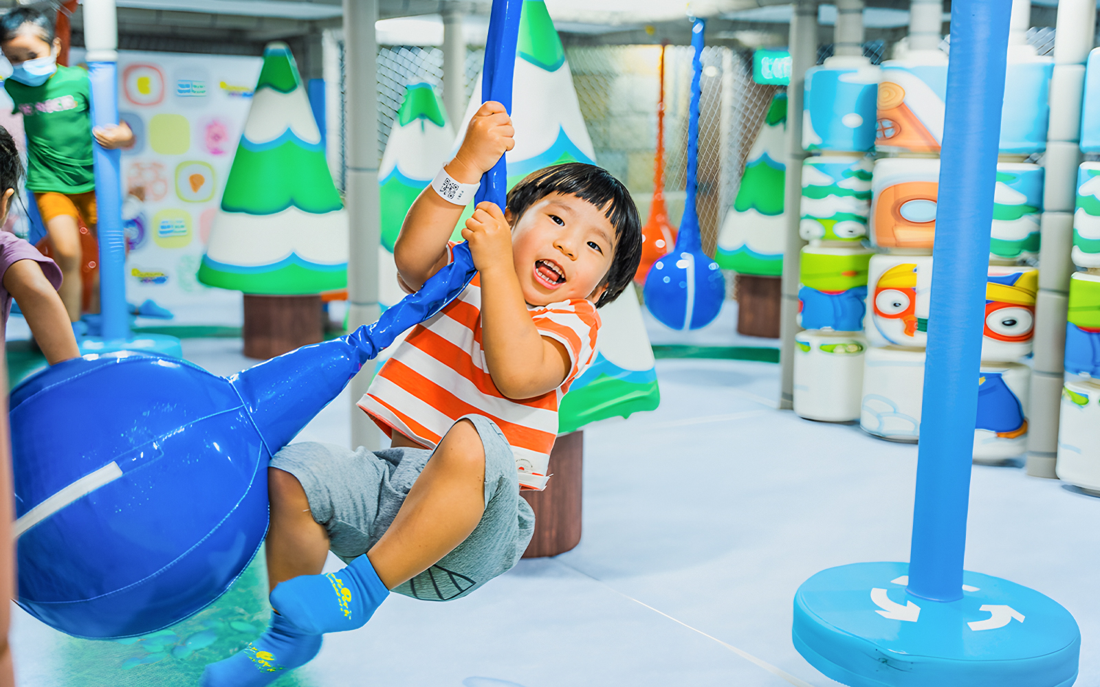 Child playing on a swing at Pororo Park Singapore indoor playground.