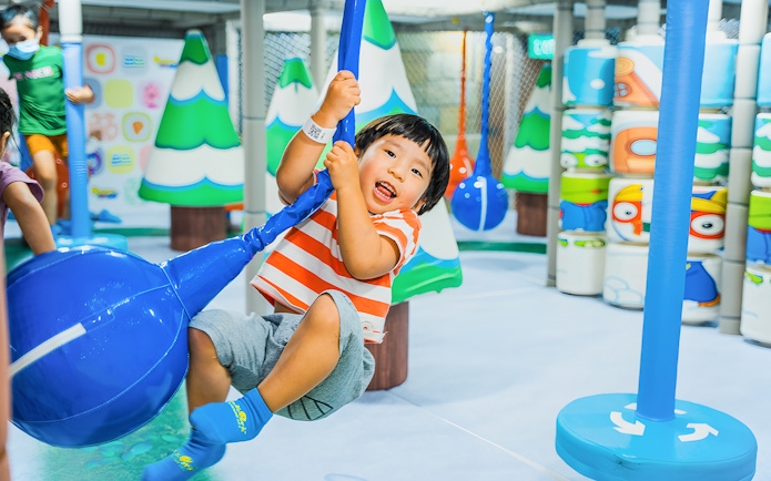 Child playing on a swing at Pororo Park Singapore indoor playground.