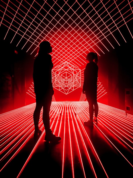 Tourists surrounded by red laser lights at Amaze Amsterdam.