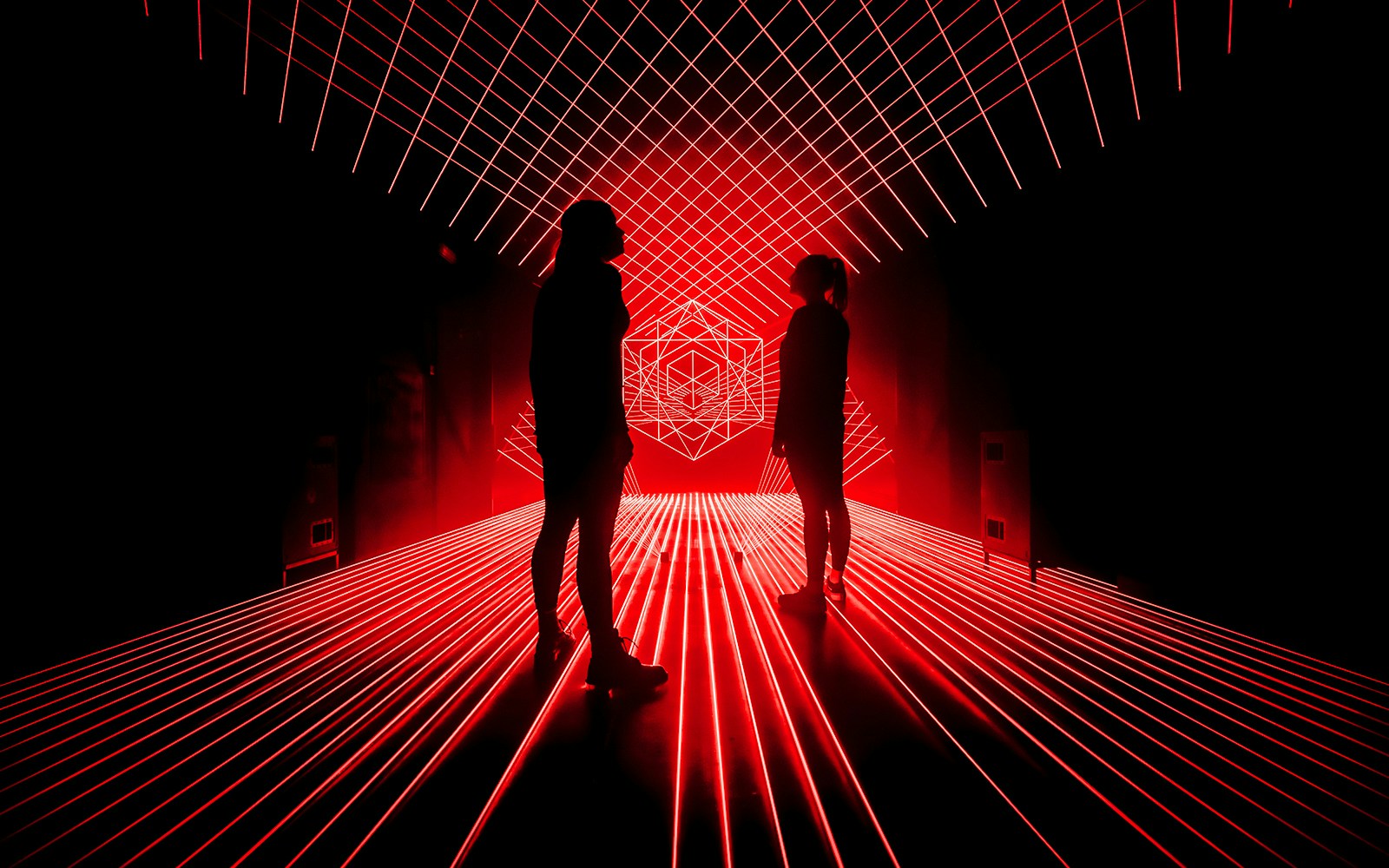Tourist interacting with laser lights at Amaze Amsterdam exhibit.