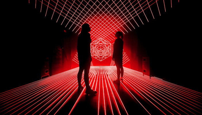Tourists surrounded by red laser lights at Amaze Amsterdam.