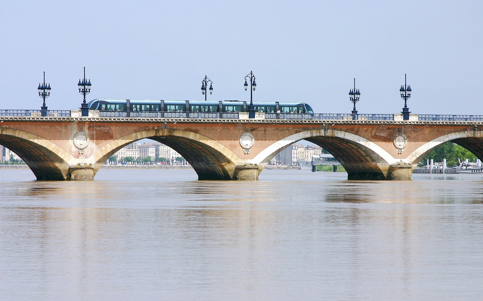 Pont de Pierre bridge with tram crossing over the Garonne River in Bordeaux, France.