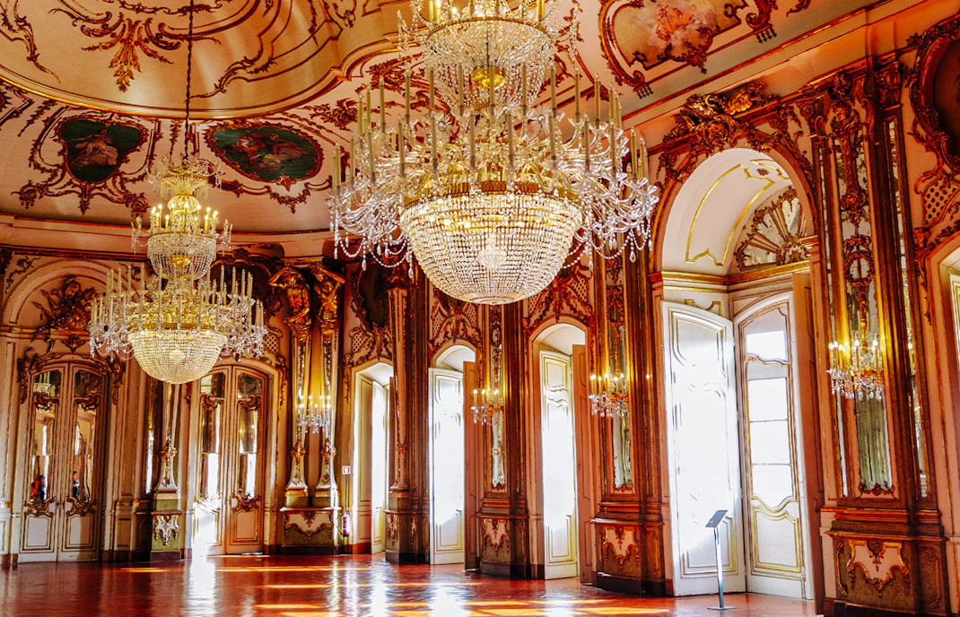 National Palace of Queluz Throne Room with ornate chandeliers and gilded decor.