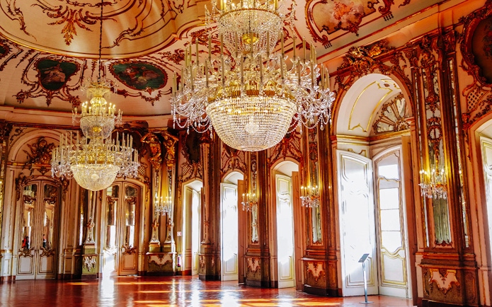 National Palace of Queluz Throne Room with ornate chandeliers and gilded decor.