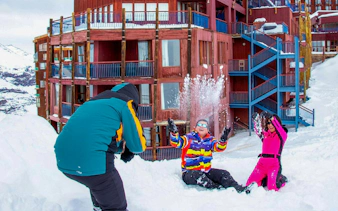 Family playing in snow at Valle Nevado resort, Chile.
