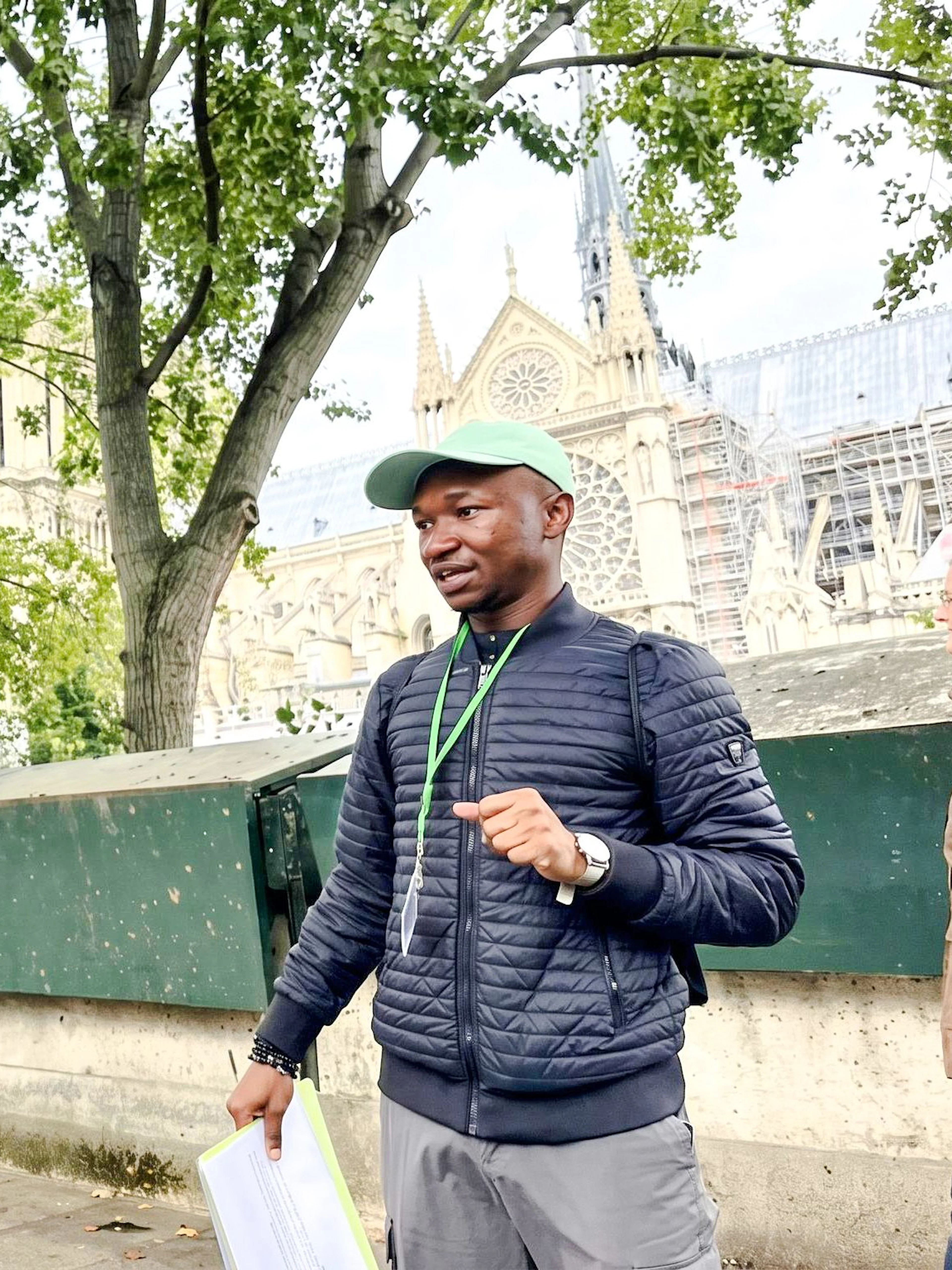 Tour guide explaining Notre-Dame's history to visitors in Paris.