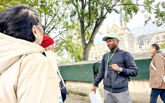 Tour guide explaining Notre-Dame's history to visitors in Paris.