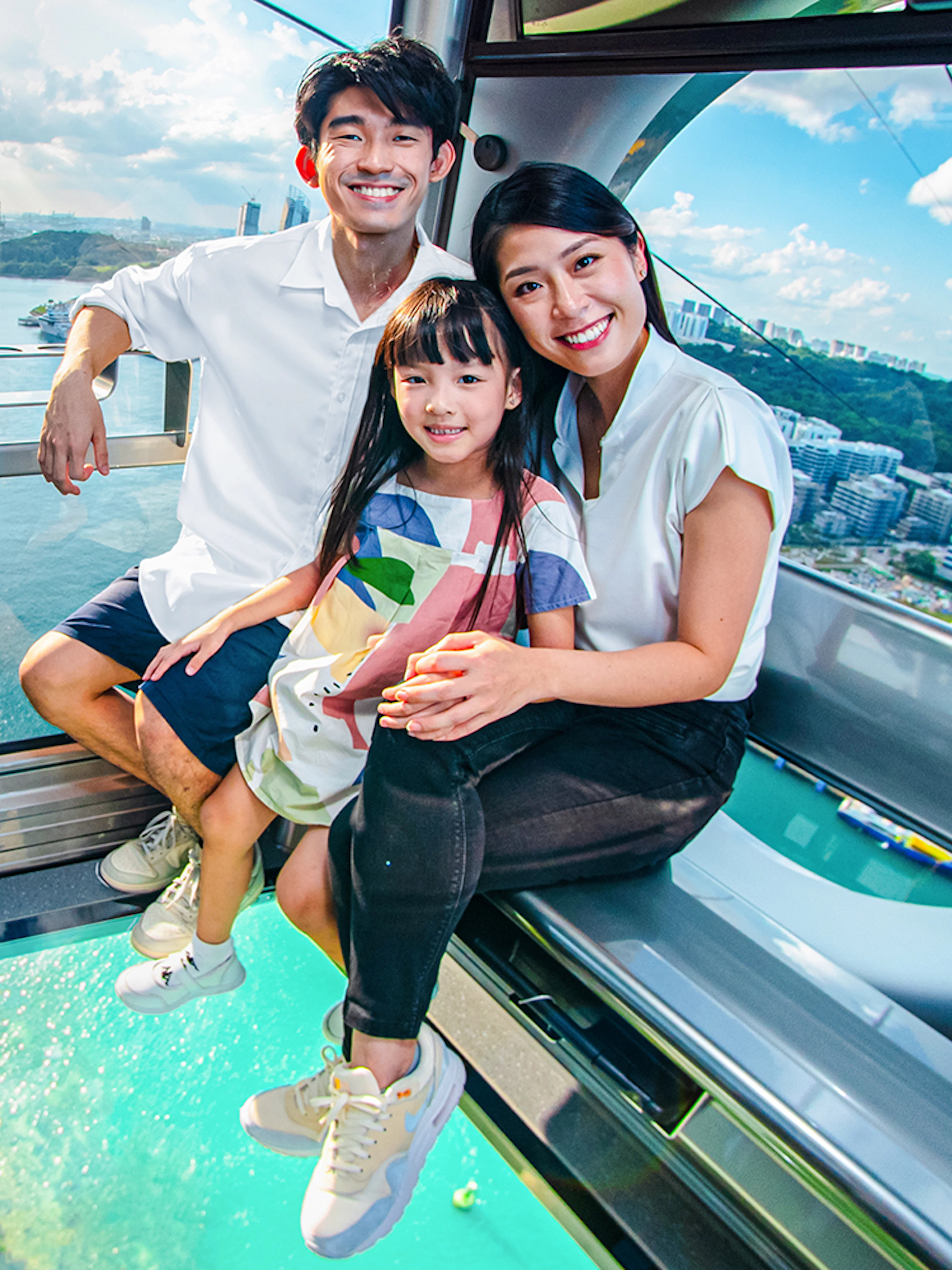 Family enjoying the view from the Sky Orb ride over a scenic waterfront.