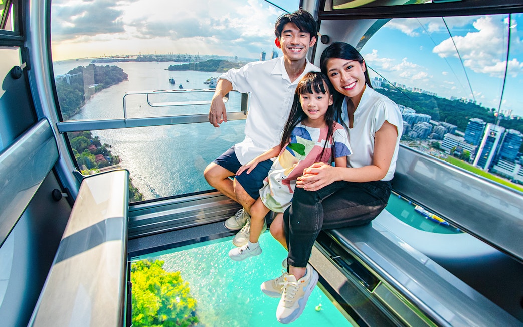 Family enjoying the view from the Sky Orb ride over a scenic waterfront.