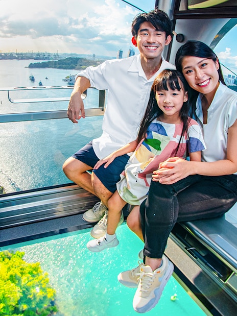 Family enjoying the view from the Sky Orb ride over a scenic waterfront.