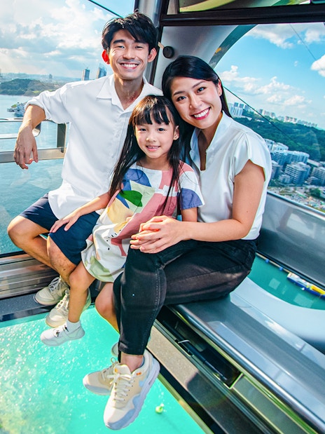 Family enjoying the view from the Sky Orb ride over a scenic waterfront.