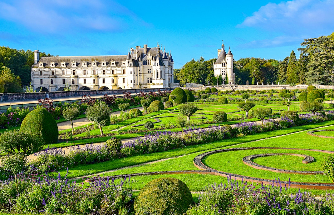 Chenonceau Castle exterior with lush gardens in Loire Valley, France.