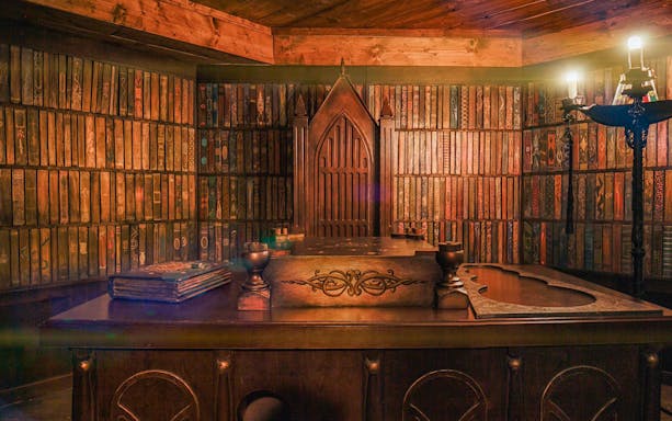 Neverland Bar & Escape Room interior with wooden decor and mysterious bookcase.