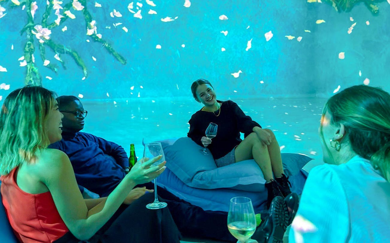 Guests enjoying drinks at Frameless Lates immersive art experience.