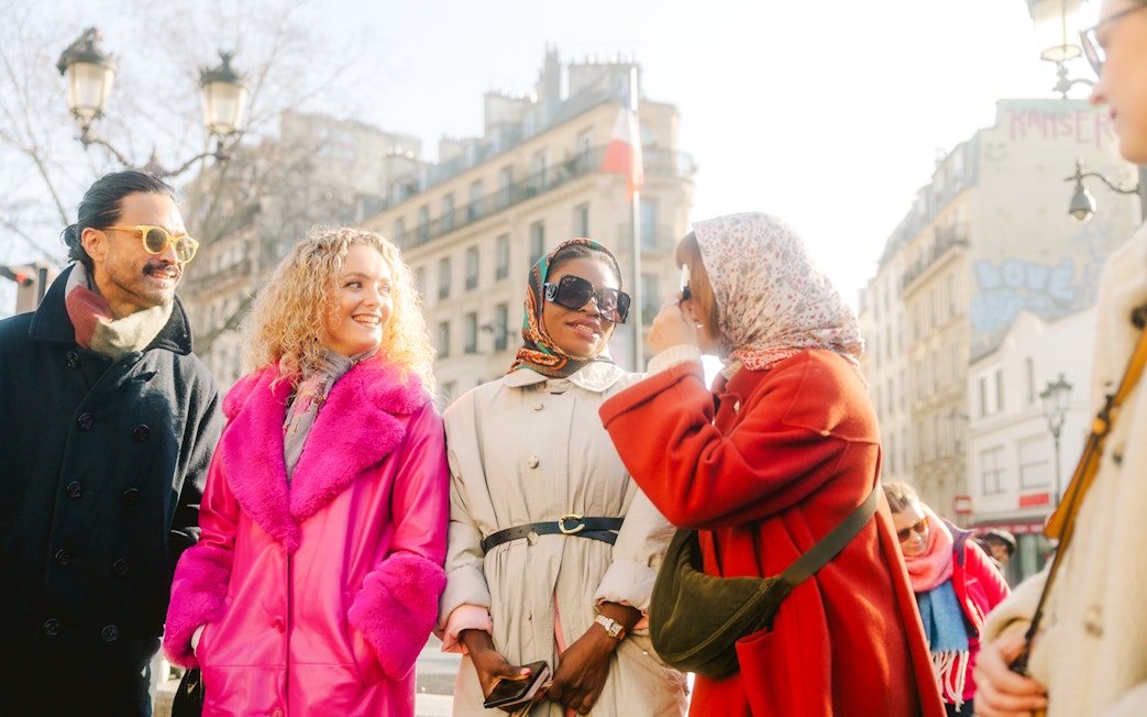 Group enjoying Montmartre Walking Tour in Paris with historic buildings in background.