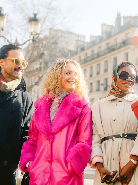 Group enjoying Montmartre Walking Tour in Paris with historic buildings in background.