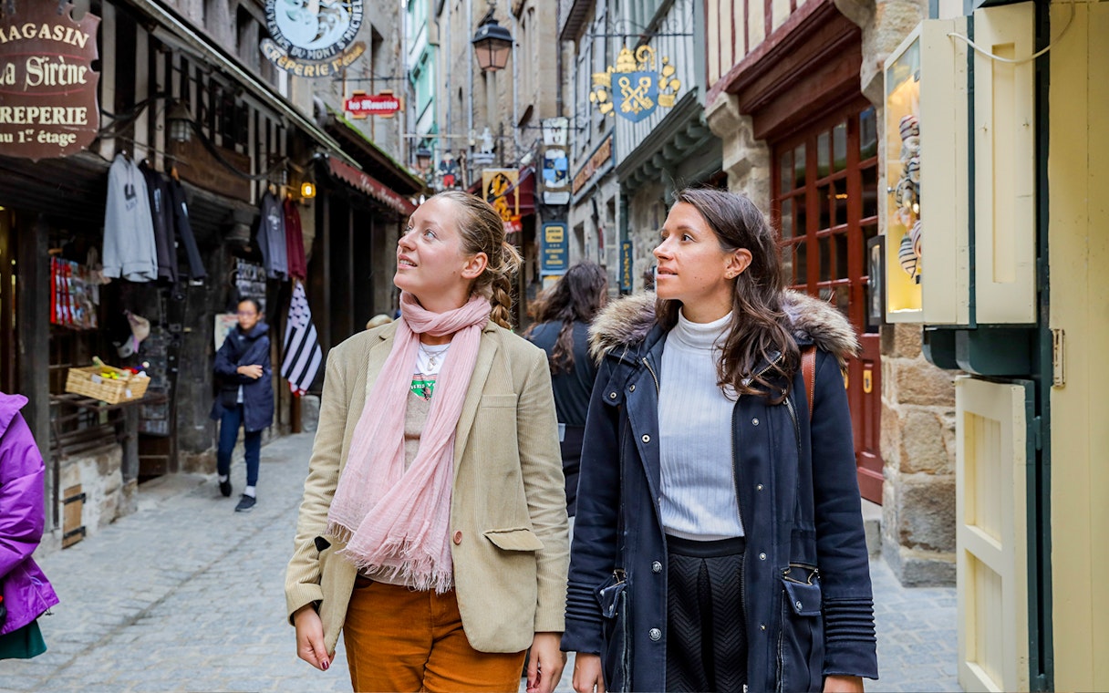 Visitors exploring the narrow streets of Mont Saint-Michel on a guided tour.