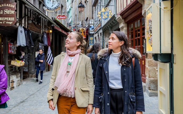 Visitors exploring the narrow streets of Mont Saint-Michel on a guided tour.
