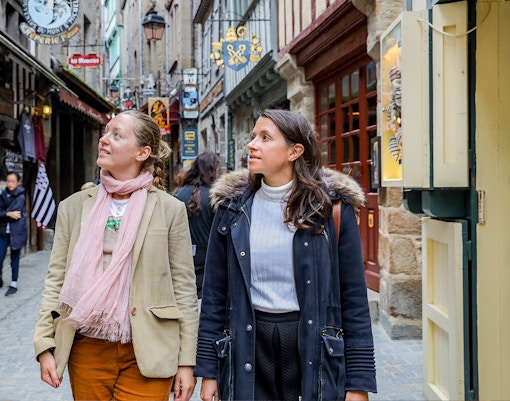 Mont Saint Michel abbey with tourists exploring the historic island on a guided tour.