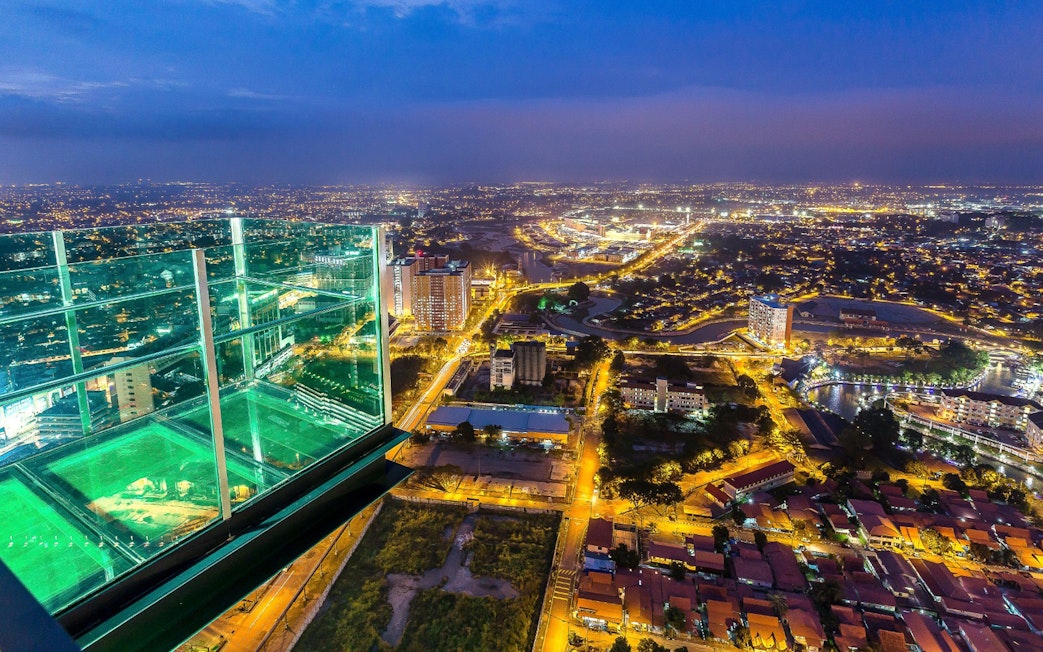 View from The Shore Sky Tower overlooking city lights at night in Melaka, Malaysia.