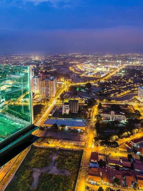 View from The Shore Sky Tower overlooking city lights at night in Melaka, Malaysia.