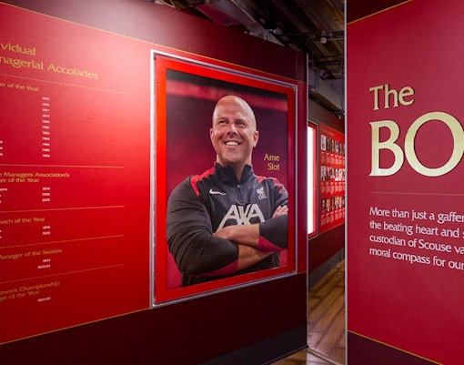 Liverpool FC Stadium tour exhibit featuring managerial accolades and a portrait of a coach.