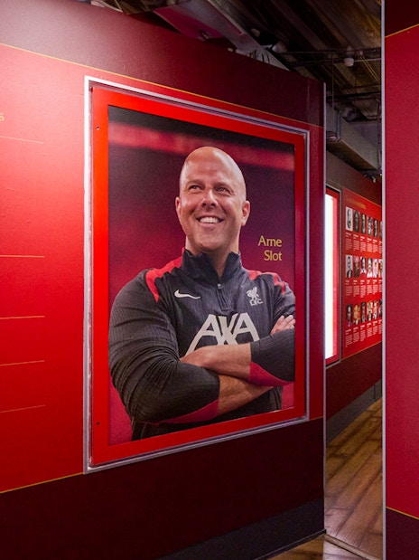 Liverpool FC Stadium tour exhibit featuring managerial accolades and a portrait of a coach.