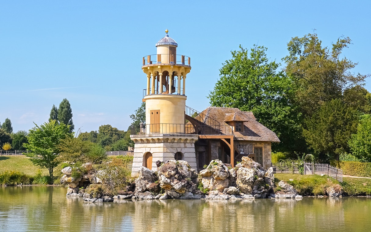 Queen's Hamlet tower and cottage by the lake in Versailles, France.