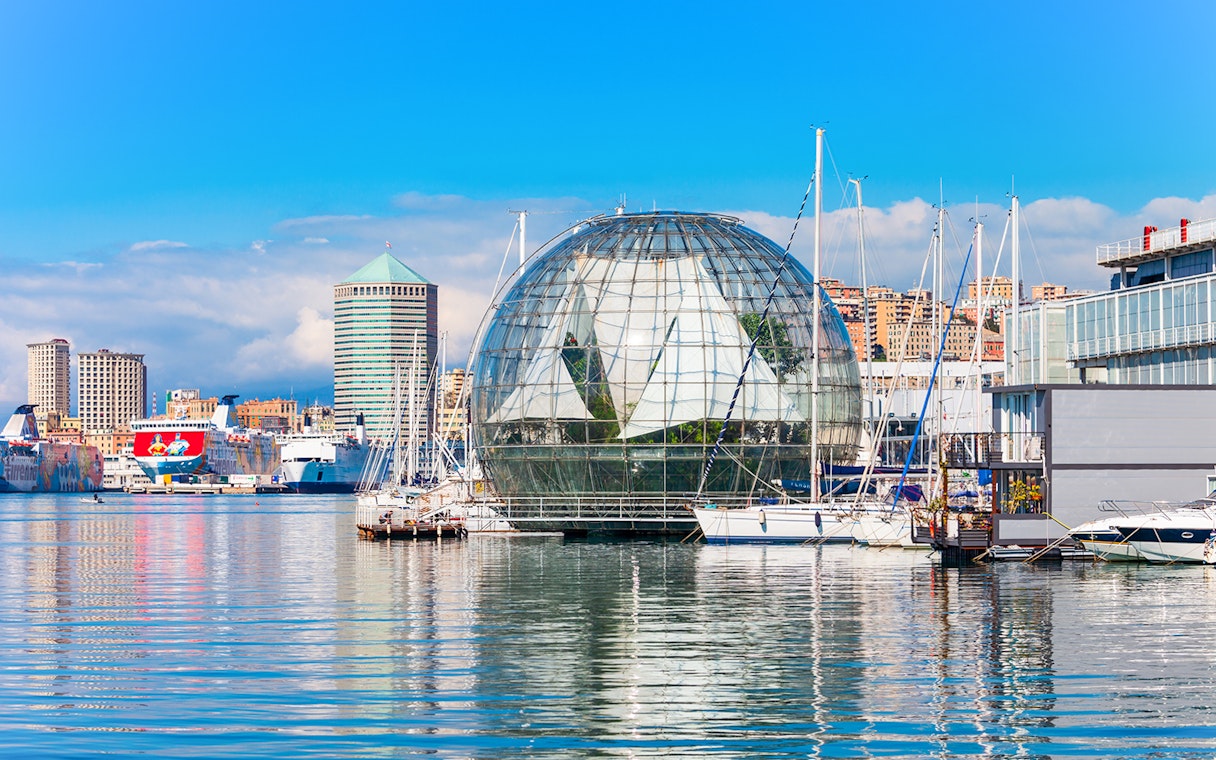 Genoa harbor with Biosphere near Aquarium of Genoa, boats and cityscape in background.