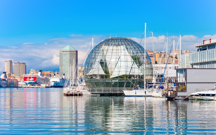 Genoa harbor with Biosphere near Aquarium of Genoa, boats and cityscape in background.