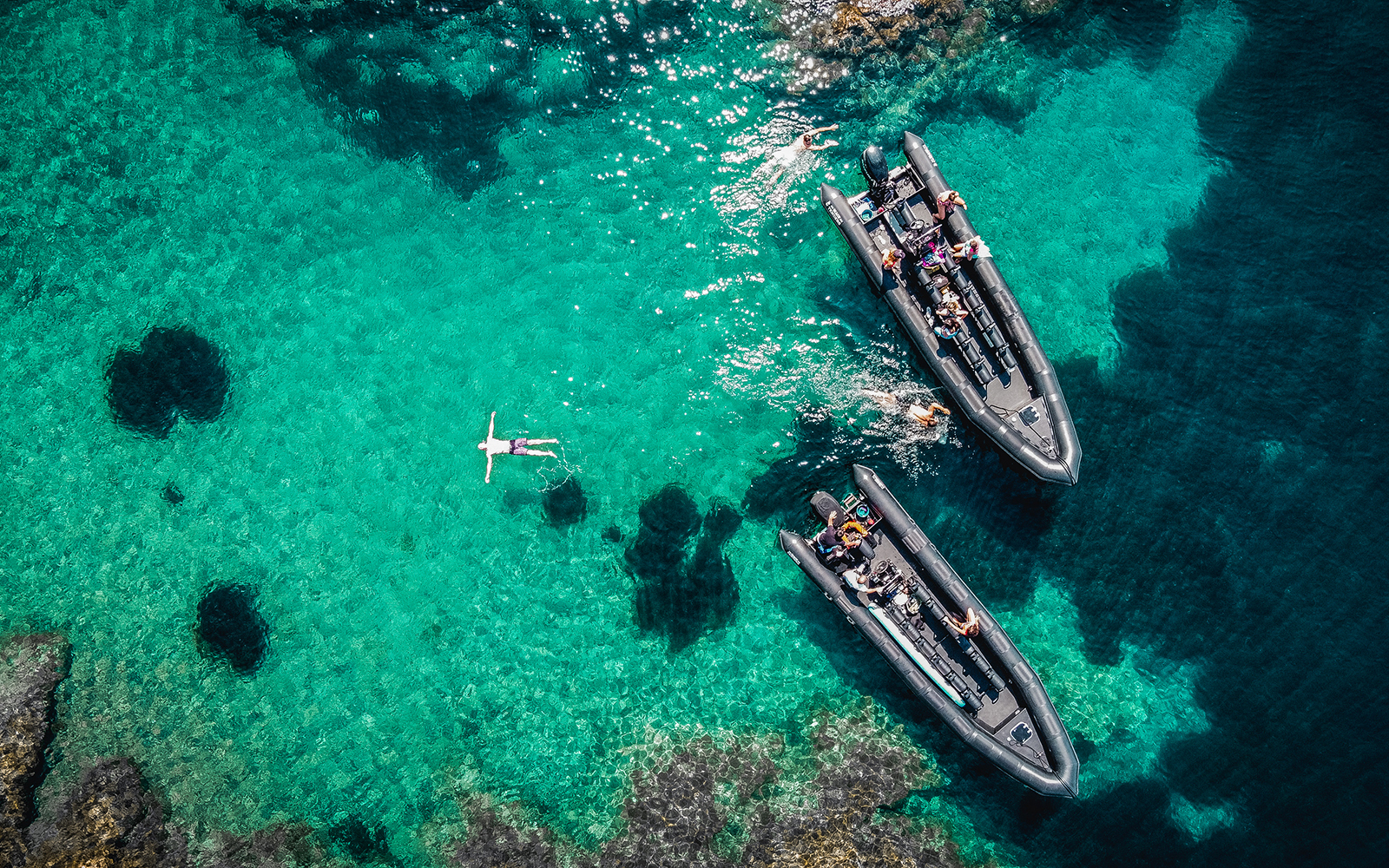 Guided boat tour in Estérel Natural Park, Cannes, with people swimming in clear blue water.